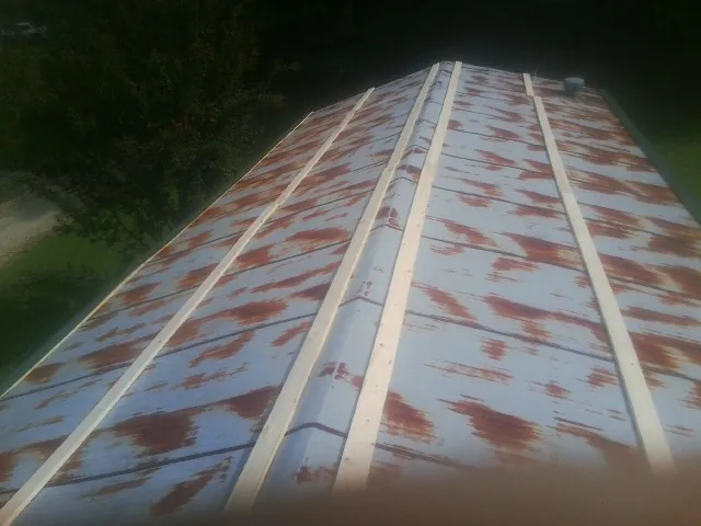 Rusted metal roof panels with new wood purlins before replacement — Storm Damage Roof Repair in Penryn by Roofing Brothers