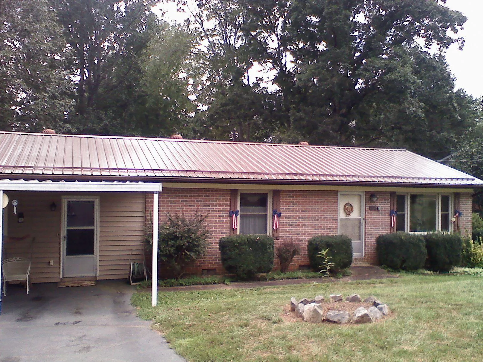 Bronze metal roof and carport on a brick ranch home — Roof Repair work by our crew in Penryn